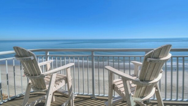 Two wooden Adirondack chairs on a balcony with a view of the ocean. - Grand Atlantic 1407- Oceanfront - Indoor/Outdoor Pools (Myrtle Beach)