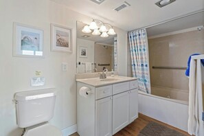 Ein Badezimmer mit Toilette, Waschbecken, Spiegel und Dusche.