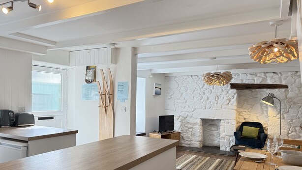 Een moderne keuken met een houten keukeneiland, een stenen openhaard en een eethoek met een tafel en stoelen.