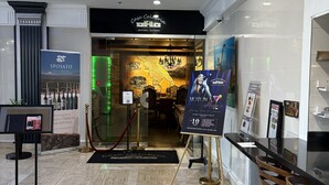A hotel lobby with a reception desk, a map of Argentina, and a sign for Motown Melting.
