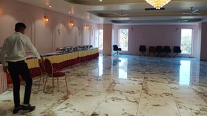 A spacious room with a marble floor, a long table with chairs, and a chandelier. - Tej Hotel & Restaurant  (Tikamgarh)