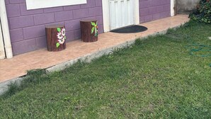 A house with a purple exterior, a white door, and a large window. - Charming 2-bedroom apartment with WiFi in Intibuca (Intibuca)