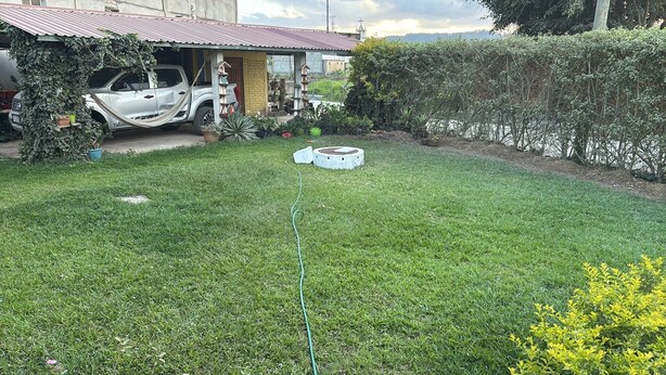 A grassy yard with a white car and a small shed. - Charming 2-bedroom apartment with WiFi in Intibuca (Intibuca)