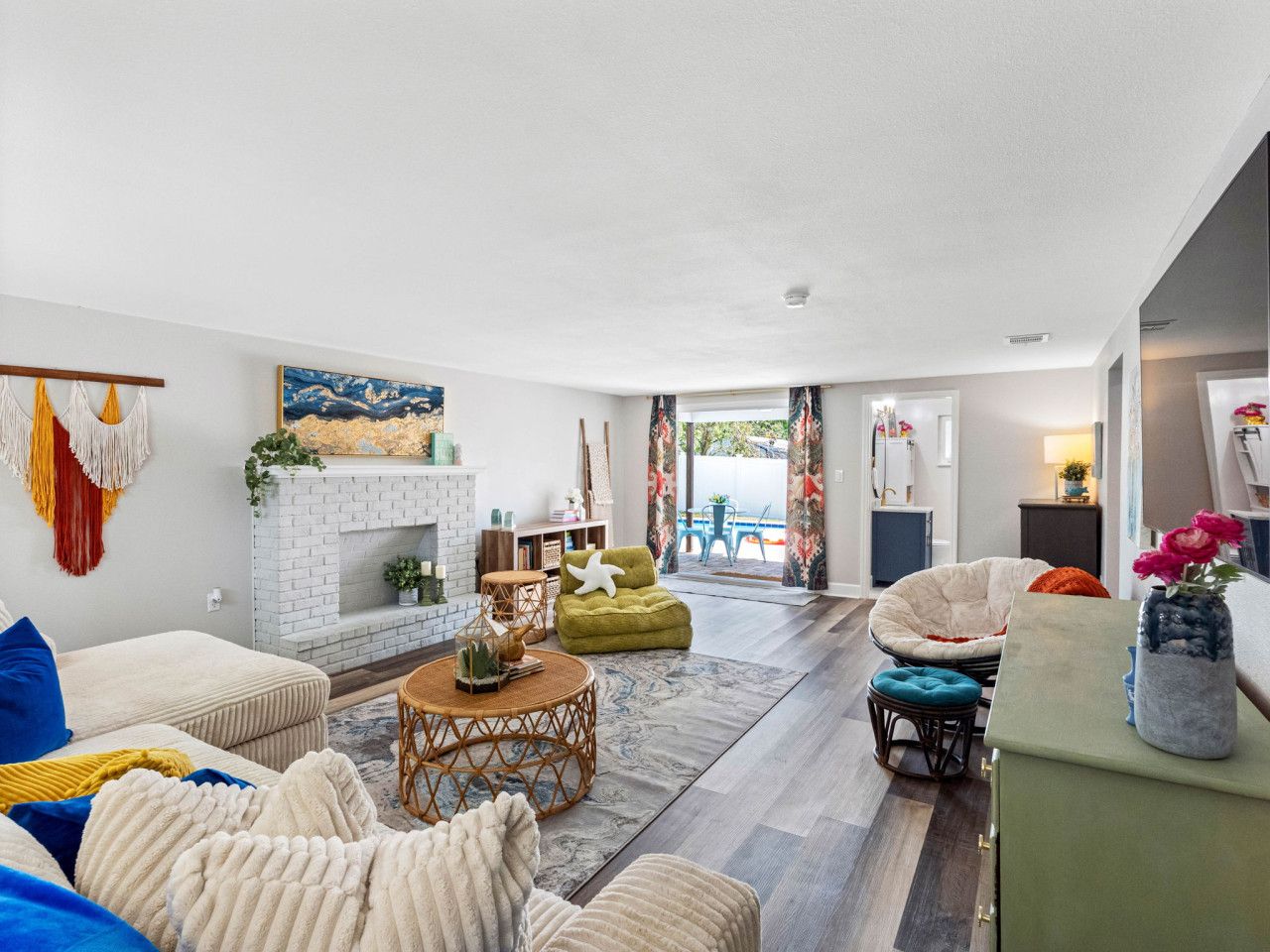A spacious living room with a fireplace, comfortable seating, and a view of the outdoors.
