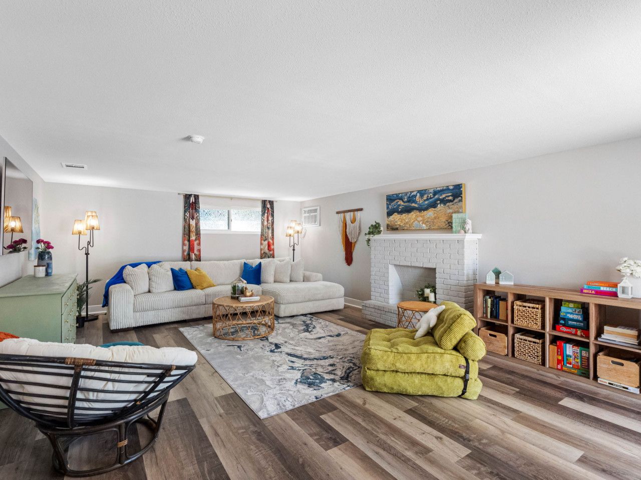 Un salon moderne avec un canapé blanc, un fauteuil jaune, une table basse et une cheminée.