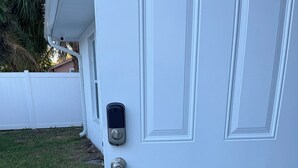 A white door with a keypad lock and a doormat with "WELCOME" written on it. - Cozy Lehigh Extended Stay (Lehigh Acres)