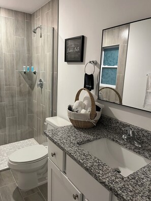 A modern bathroom with a shower, toilet, and sink. - Cozy Lehigh Extended Stay (Lehigh Acres)