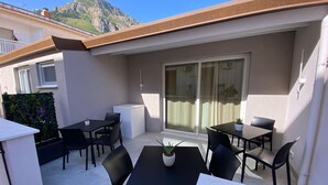 A terrace with outdoor seating, a potted plant, and a view of a mountain. - Alumaro House (Castellammare del Golfo)