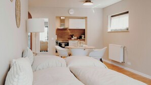 Un dormitorio moderno con una cama grande, un escritorio y una kitchenette.