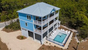 A two-story building with a pool, surrounded by trees. - Ocean View, Modern, Elegant Oasis With Private Pool In Gated, Coastal Community! (Eastpoint)