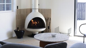 Una sala de estar moderna con chimenea, una mesa redonda y asientos cómodos.