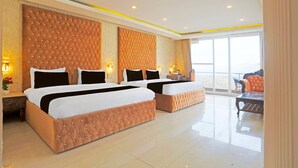 A hotel room with two large beds, a sofa, and a view of the outdoors. - Stylish Room With Mesmerizing View Dharamshala (Dharamshala)