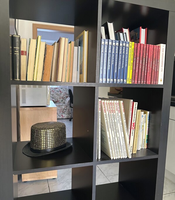 Una estantería con varios libros, un adorno y una caja de madera.
