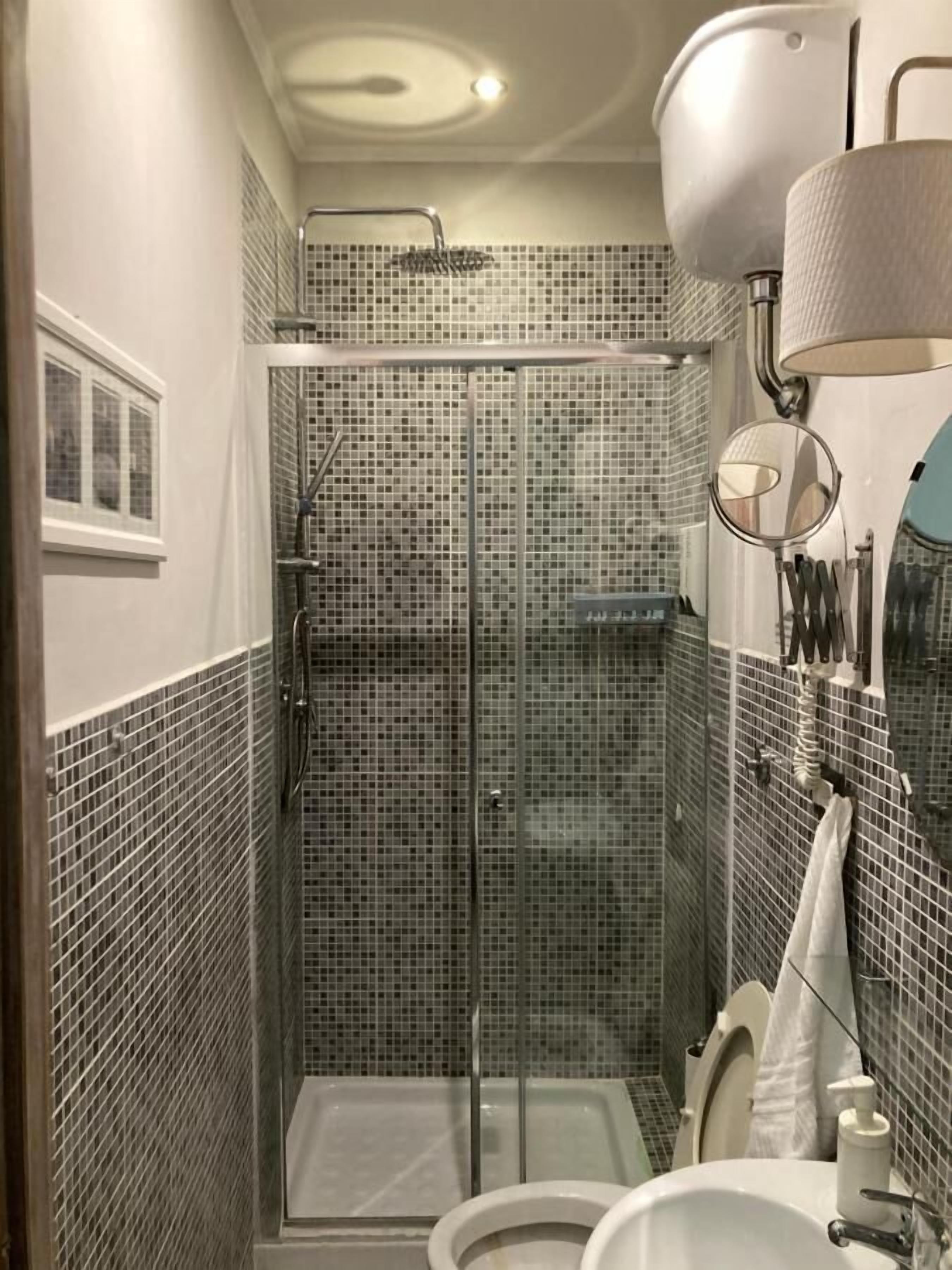 Un baño con ducha de vidrio, inodoro y lavamanos.