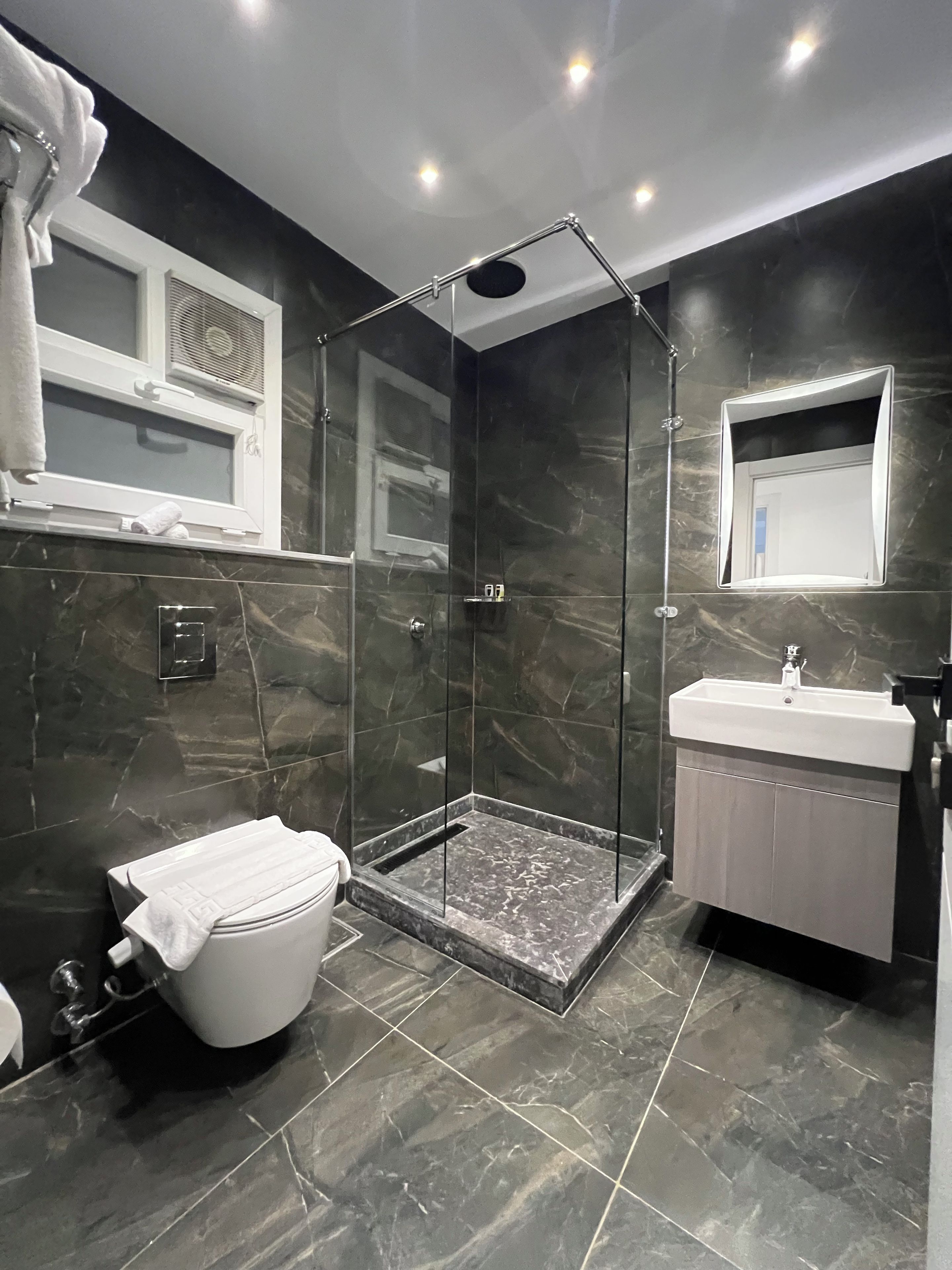Un baño moderno con ducha de vidrio, inodoro y lavabo.