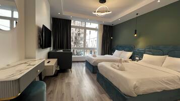 Habitación de hotel moderna con una cama grande, un escritorio y vistas al exterior.