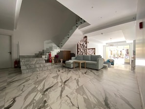 A spacious living area with a marble floor, a staircase, a sofa, and a decorative partition. - Onyx Pyramids Boutique Hotel (Giza)