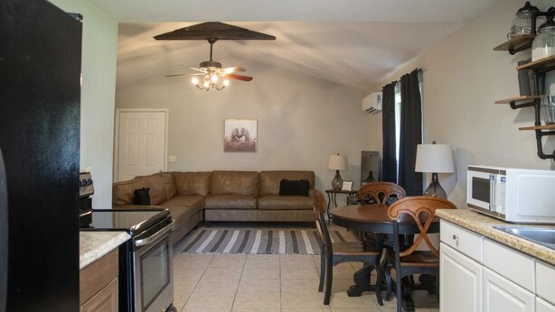 Un espacio habitable compacto con kitchenette, comedor y sofá.