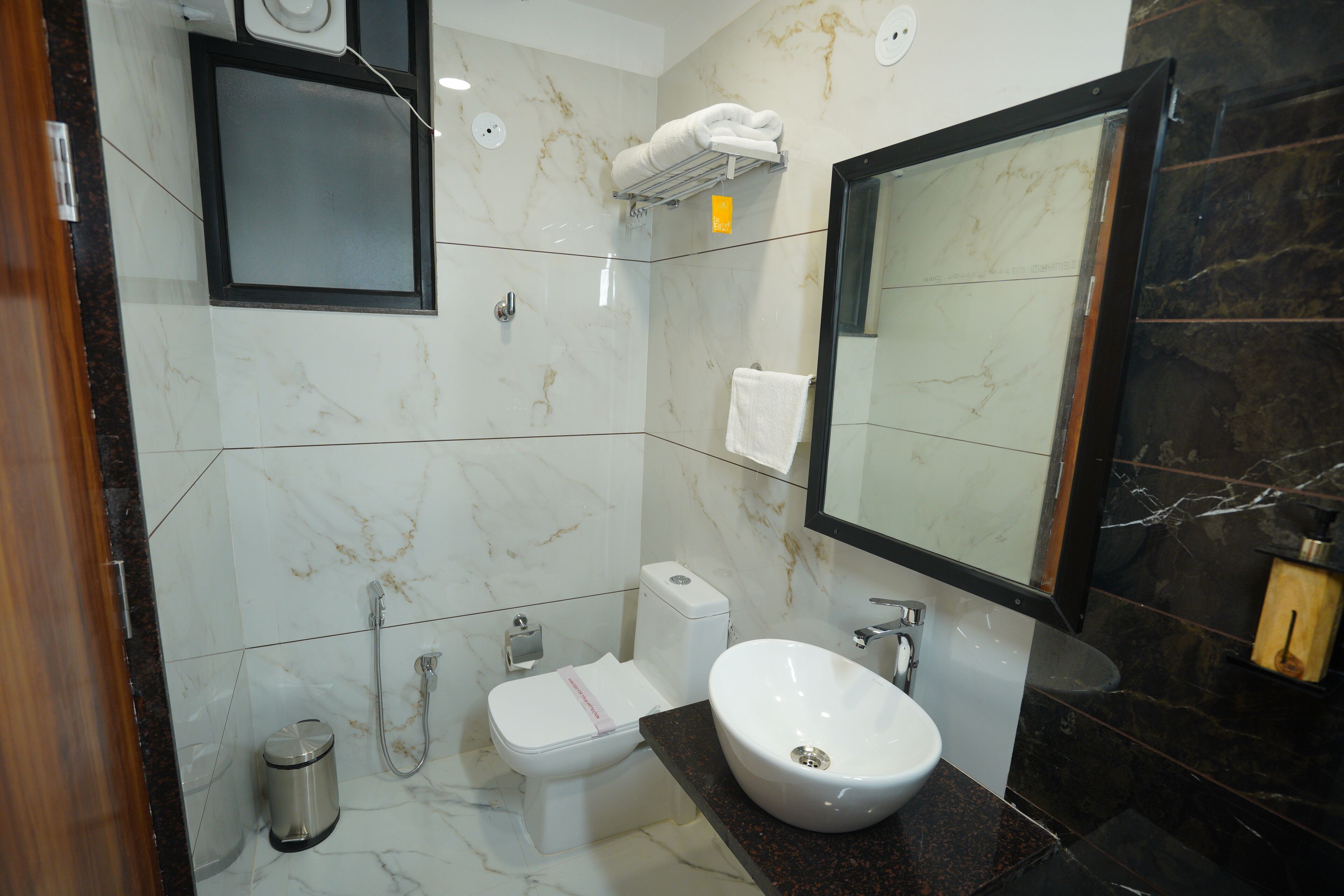A bathroom with a toilet, bidet, sink, and mirror.