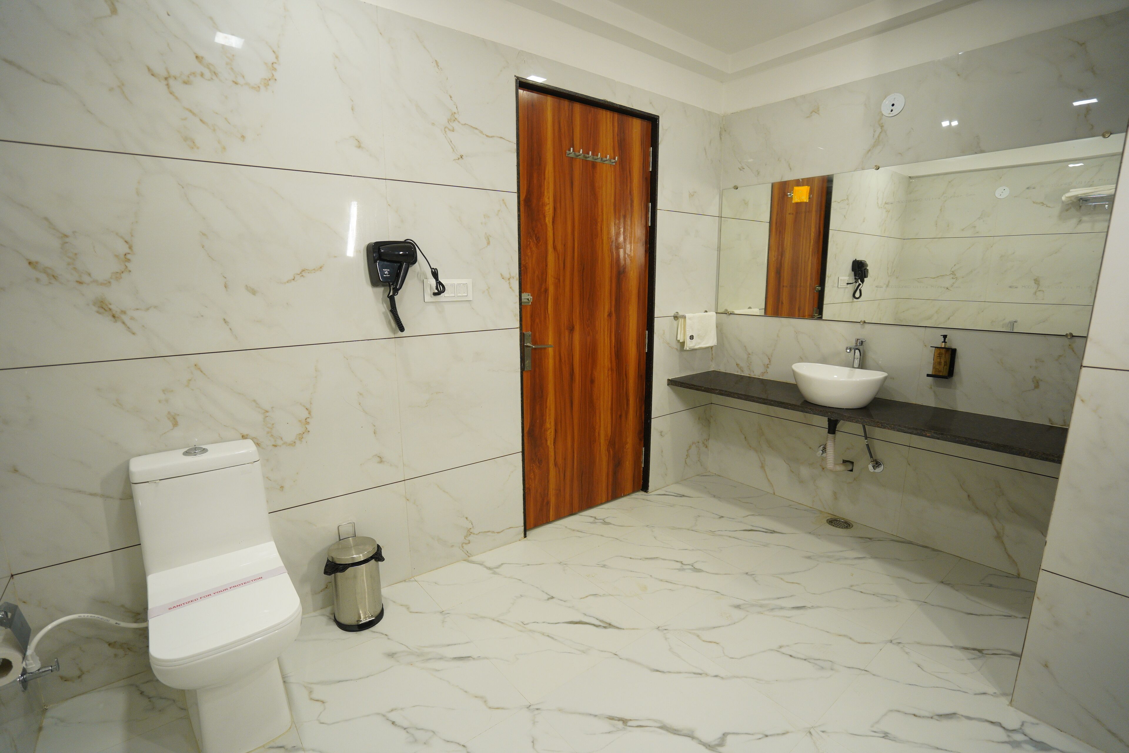 A bathroom with a toilet, sink, and mirror.
