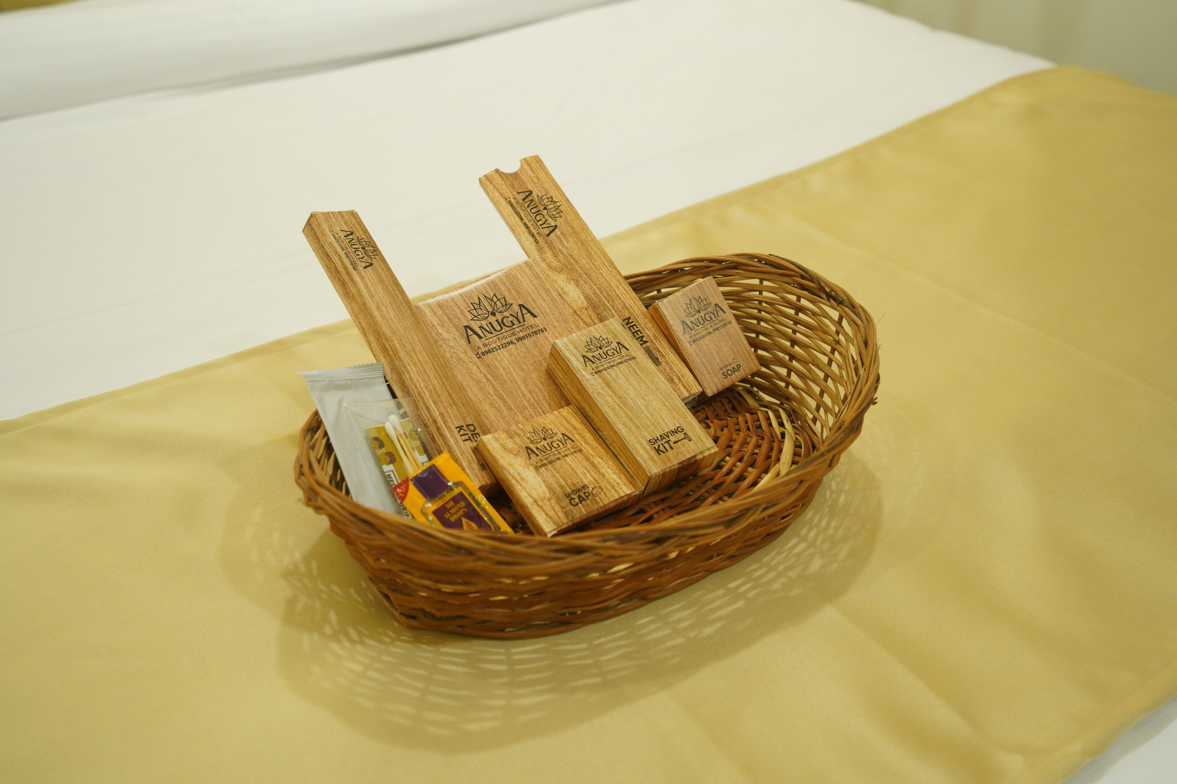 A wicker basket containing toiletries on a bed with a yellow sheet.