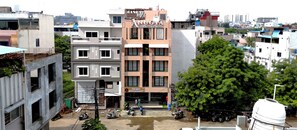 A multi-story building with a sign for 'Angola Boutique Hotel' and 'The Best Restaurant' on the ground floor. - Anugya - A Boutique Hotel (Indore)