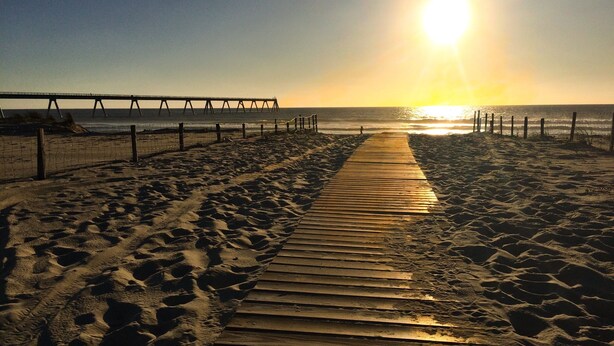 A wooden boardwalk leading to a pier on a beach. - Spacious family home on the Arcachon basin (La Teste-de-Buch)