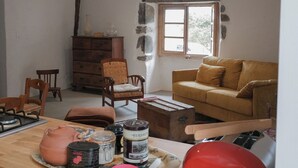 Een woonkamer met een houten tafel, een bank, een raam en een open haard.