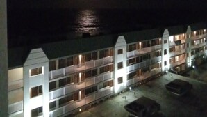 Un hôtel à plusieurs étages doté de balcons, d’un parking et offrant une vue sur l’océan.