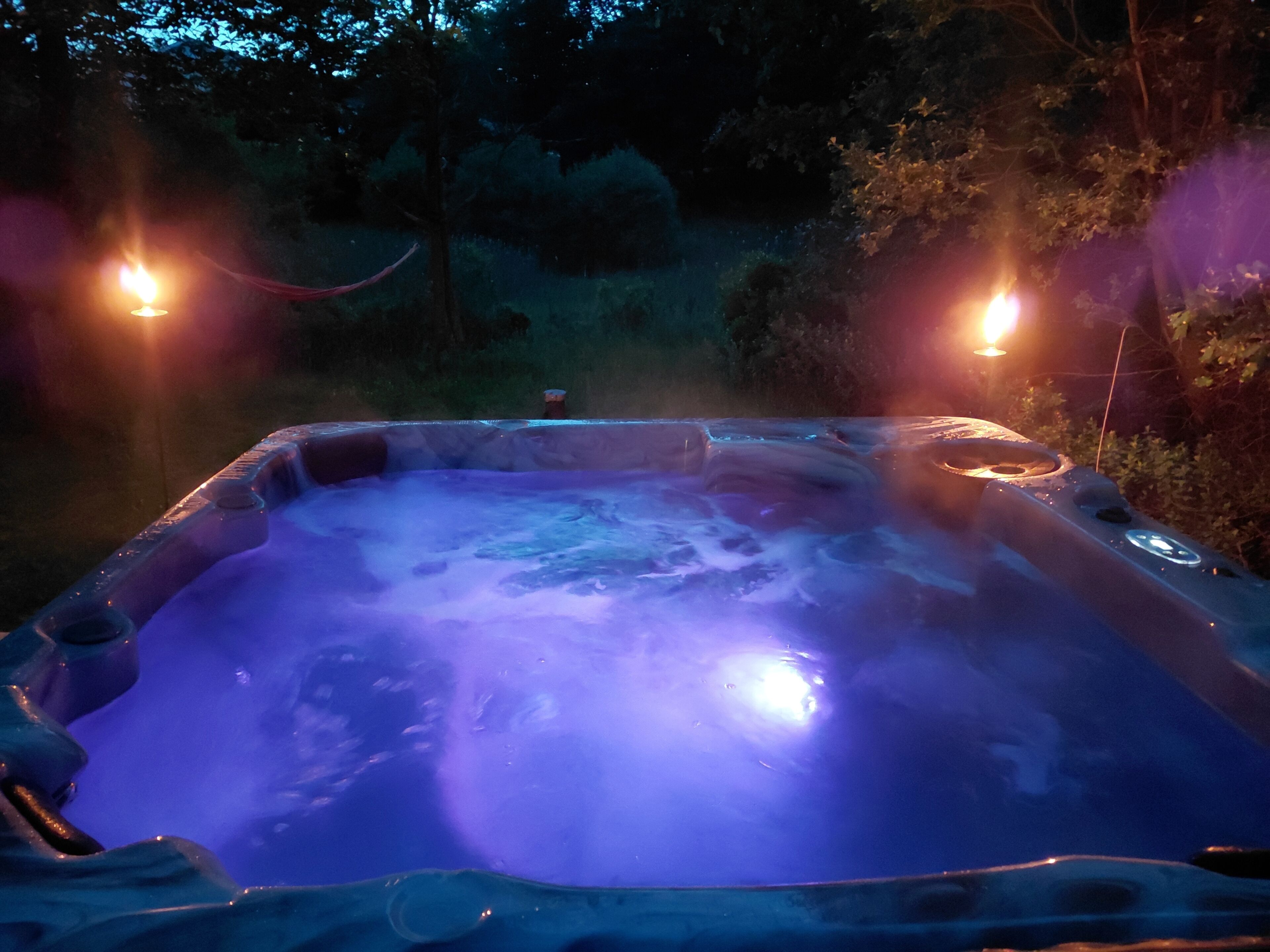 A hot tub with a view of a forested area.