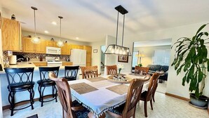 A modern kitchen with wooden cabinets, a central island, and pendant lighting. - Charming Family Friendly House, Hot tub, Playroom (Long Pond)