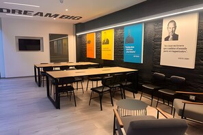 A modern conference room with a black and white color scheme, featuring tables and chairs arranged for meetings.