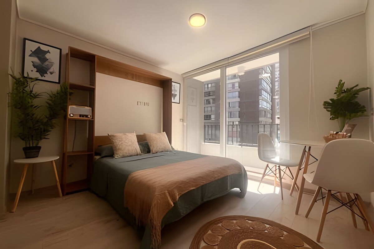 A modern bedroom with a bed, bedside tables, a desk, and a chair.