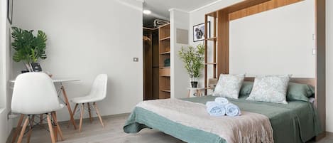 Une chambre à coucher comprenant un lit, un bureau, des chaises et une armoire.