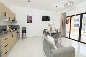 Una cocina moderna con comedor, televisor de pantalla plana y vistas al exterior.