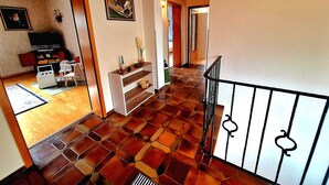 A spacious living area with a tiled floor, a television, and a dining table. - Charming, family-friendly vacation apartment in the heart of the Volcanic Eifel (Niederstadtfeld)