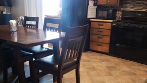 A kitchen with wooden cabinets, a refrigerator, a microwave, and a stove. - Waterfront Home on Chadakoin River! 10 minutes to Chautauqua Lake! (Jamestown)