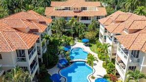 A resort with multiple buildings, a central swimming pool, and surrounding greenery. - Pro Cab Paradise Condos Cabarete (Cabarete)
