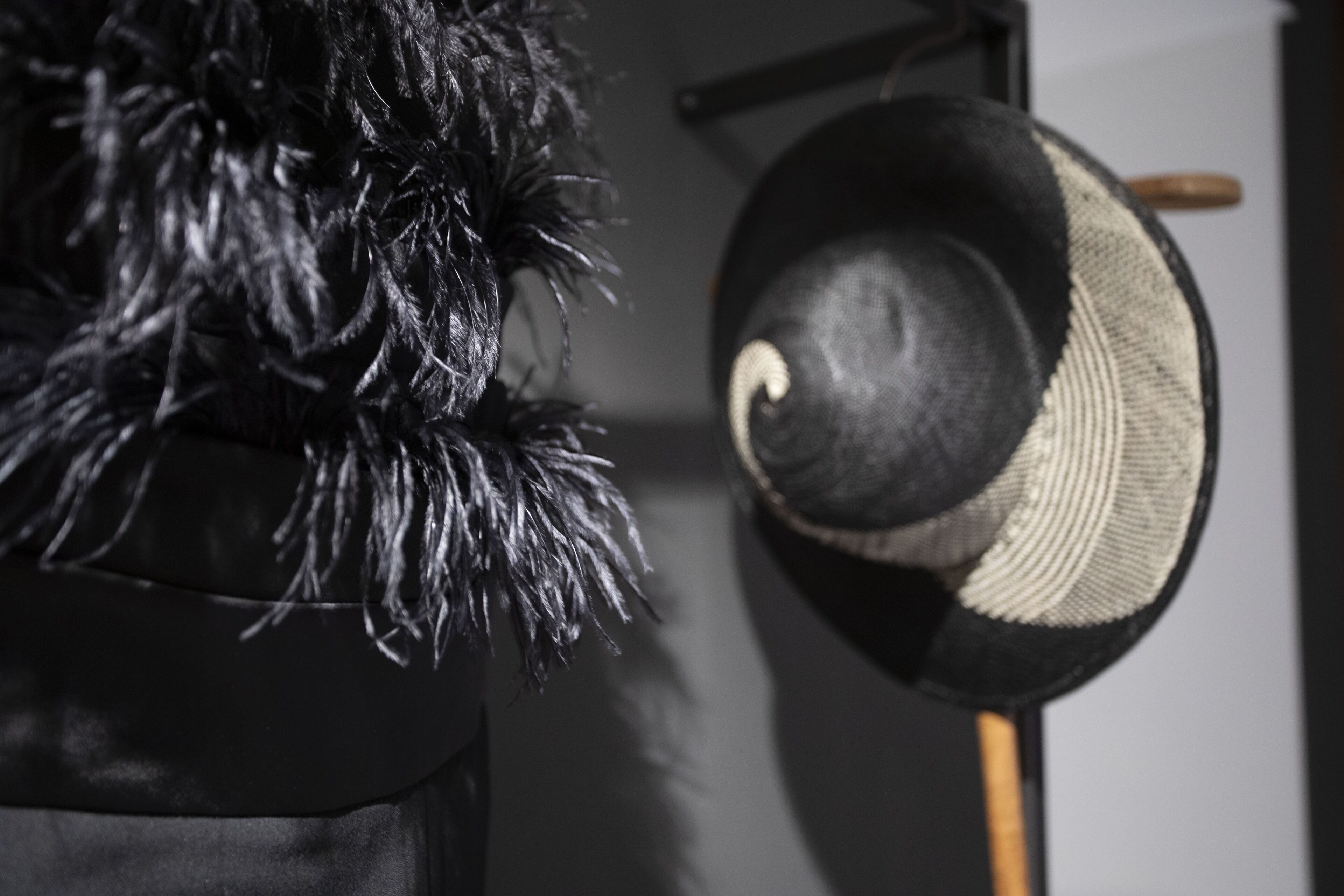 Un sombrero con un adorno de plumas y un mango de madera.