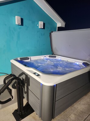 A hot tub with a digital control panel, set against a turquoise wall. - Cozy Blue 4 Miles to beach. Pet Friendly,Hot tub, public pool 1.5mi (Englewood)