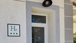 A building entrance with a sign reading "HR" and a small awning above the door. - HOTEL RURAL LA TEJA (Segura de León)