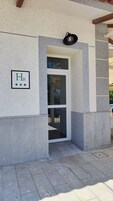 Entrada de un edificio con un letrero que dice "HR" y un pequeño toldo sobre la puerta.