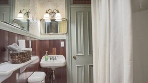 A bathroom with a white sink, a mirror above it, and a wooden vanity. - Rustic Charm / King Bed + Roku / Private Bath (Shamokin)