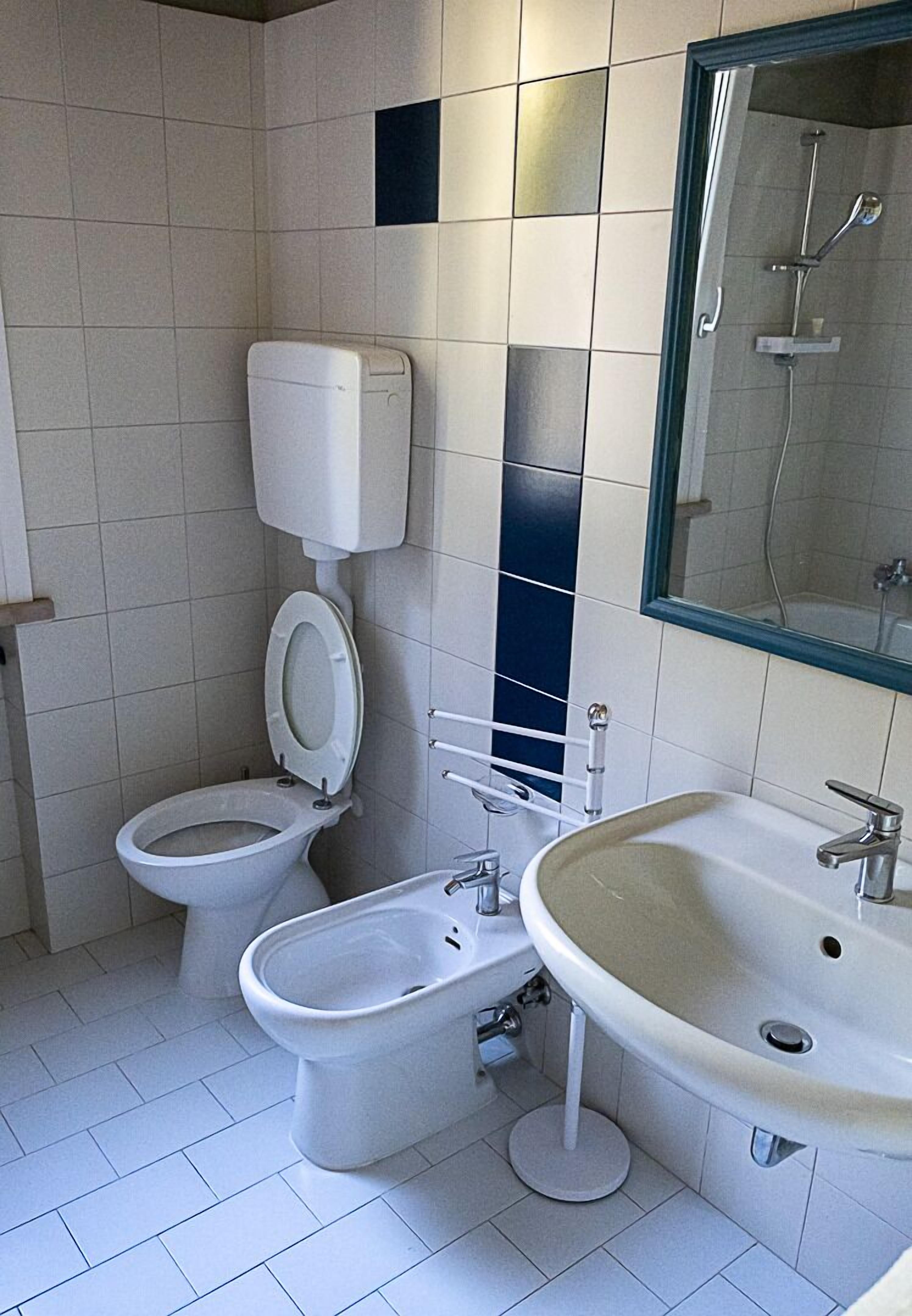 A bathroom with a toilet, bidet, and sink.