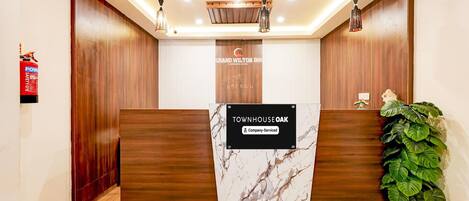 A reception desk with a marble top, wooden paneling, and a sign indicating 'Townhouse Oak'.