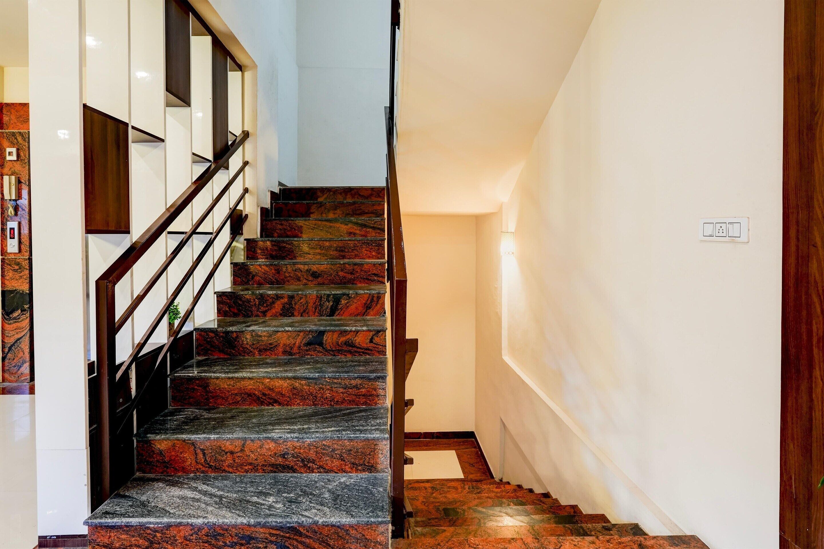 A staircase with a wooden handrail and marble steps.