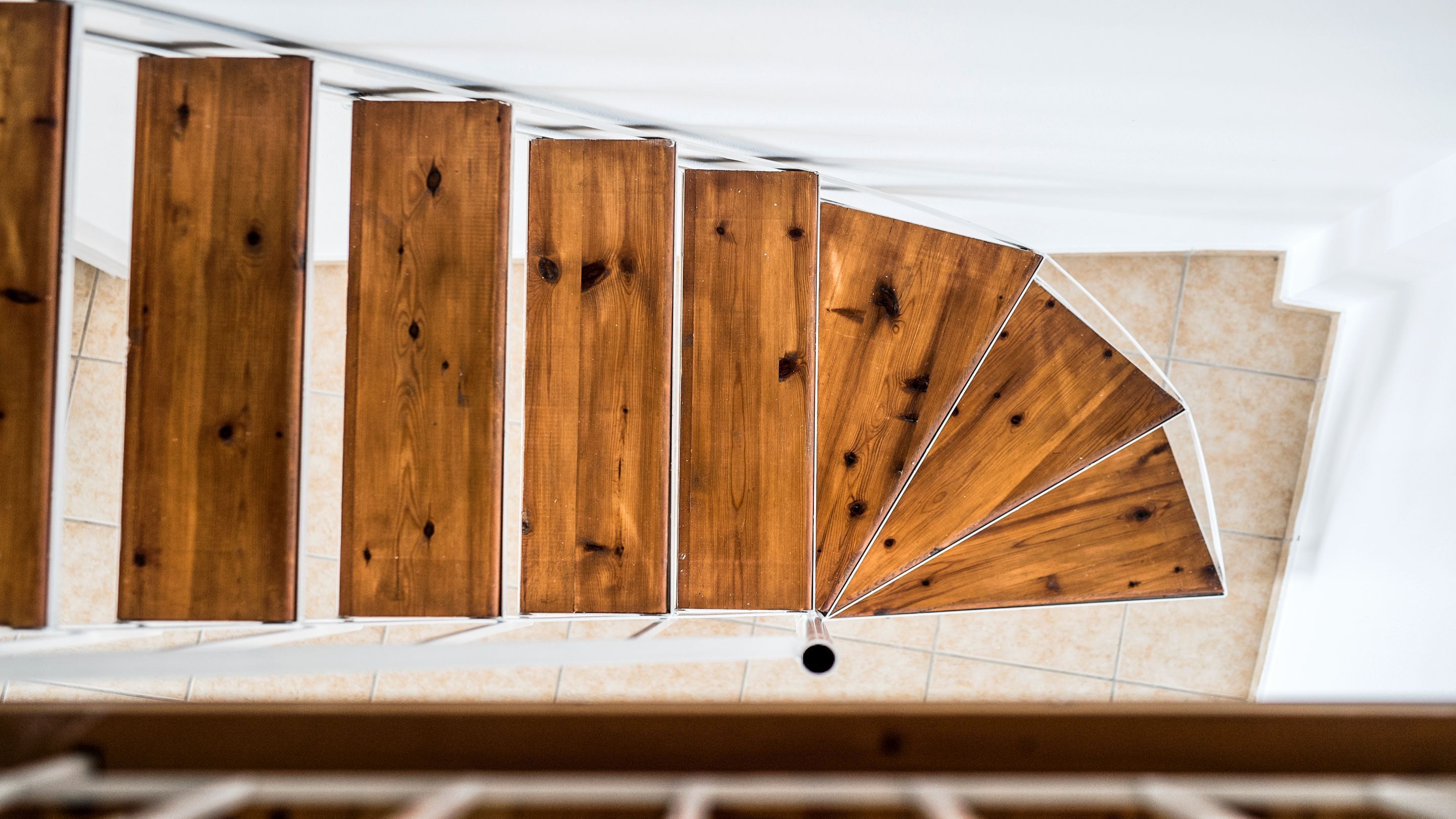 Una scala in legno dal design moderno che conduce a un piano superiore.