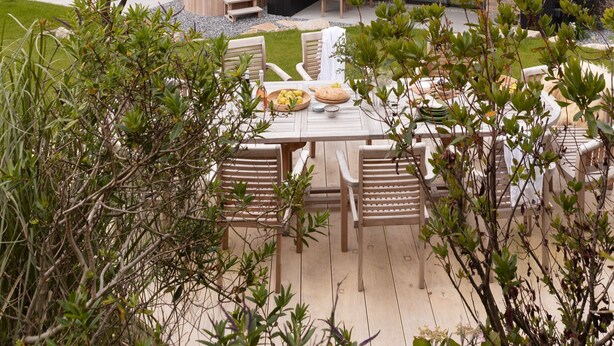 A modern house with a patio, outdoor seating, and a hot tub.
