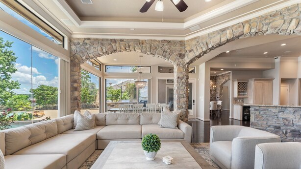 A spacious living room with a large sectional sofa, a coffee table, and a stone archway. - Waterfront home, 6 bedrooms private pool and dock on Lake Conroe (Montgomery)