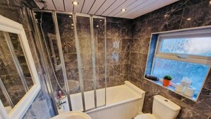 Un baño con bañera, inodoro y lavamanos.